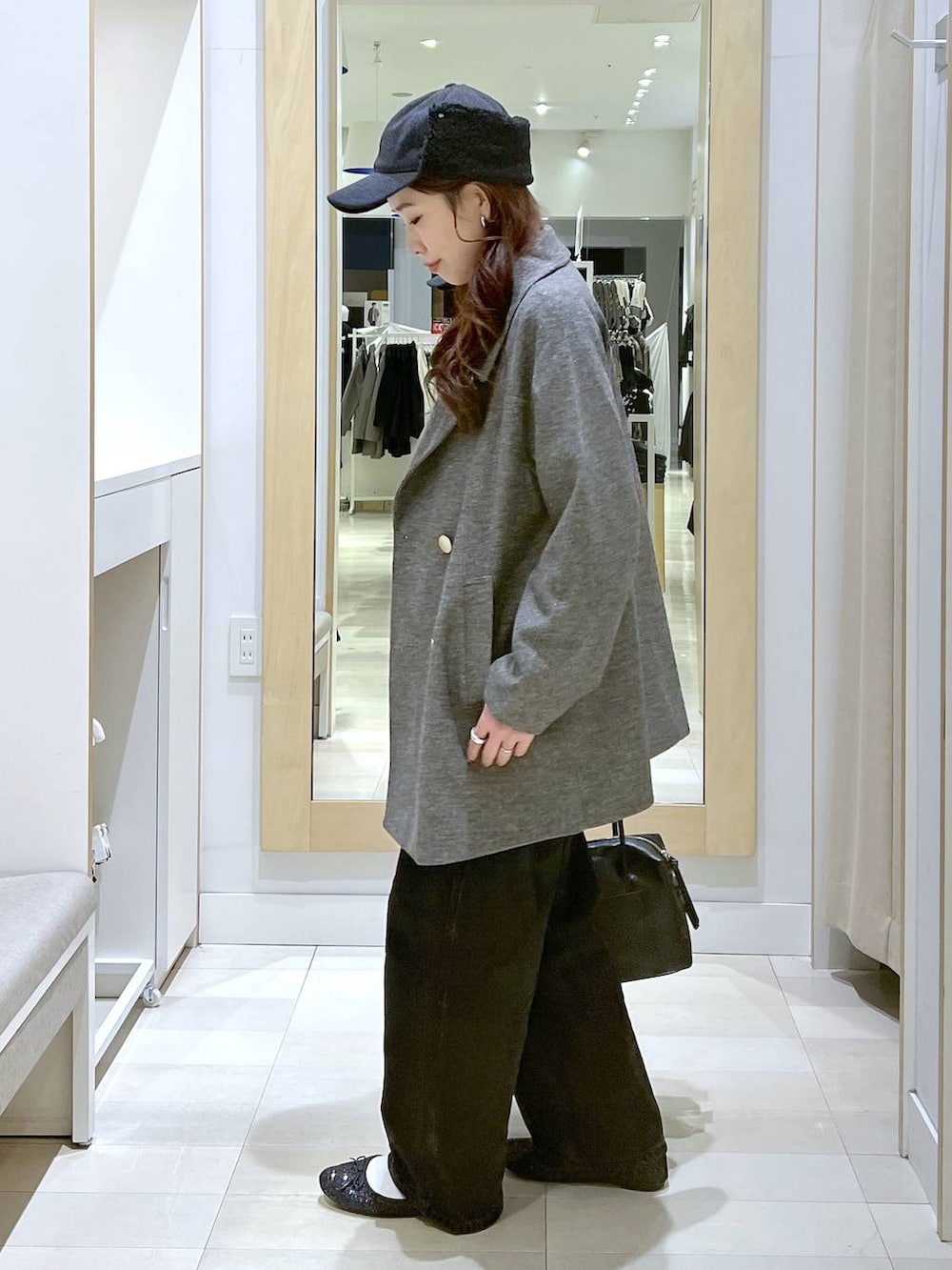 ブラック系のバレエシューズ、ブラック系のボストンバッグ、ブラック系のデニムパンツを着用したレディースの秋コーディネートの2枚目の写真