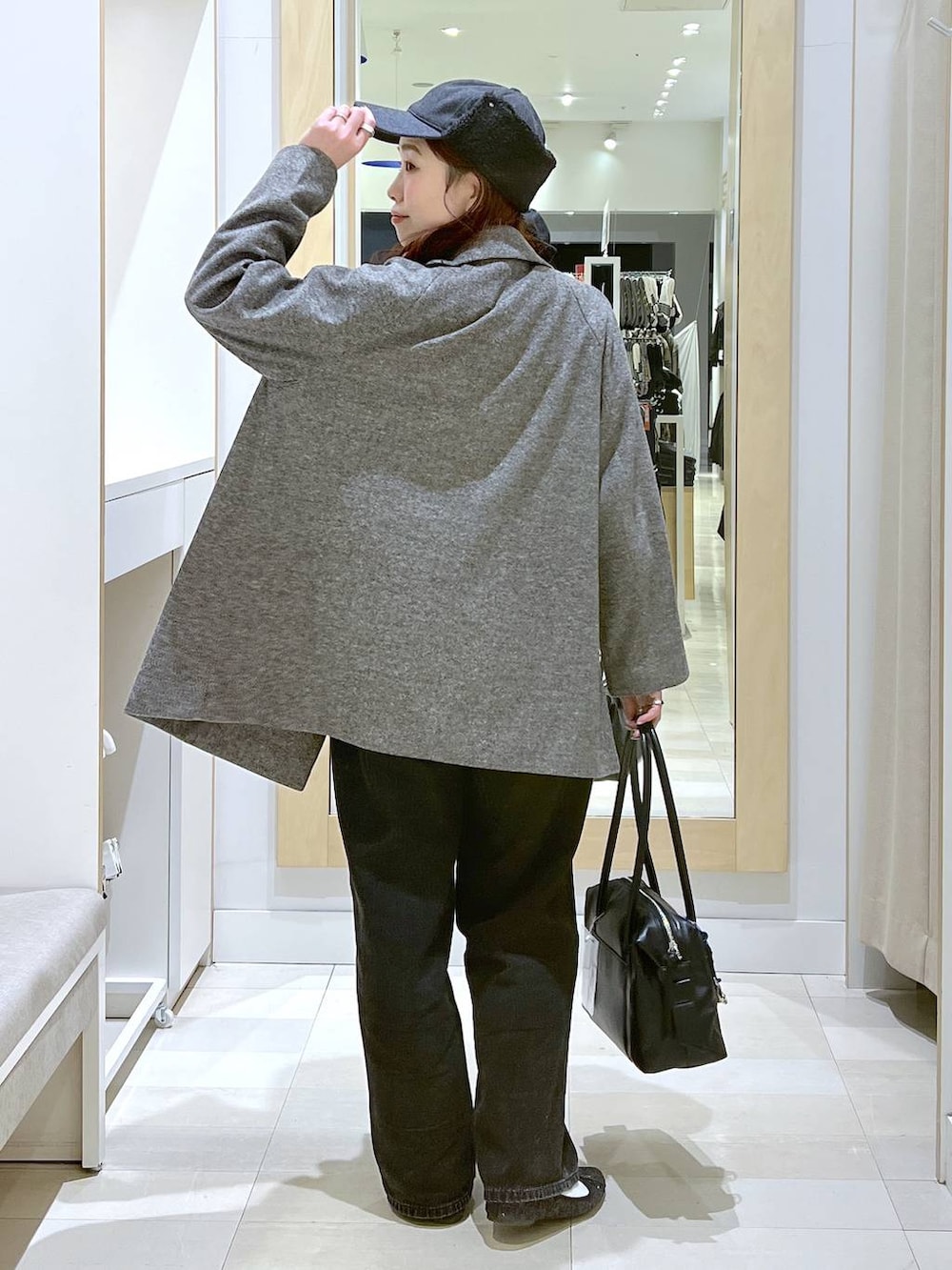 ブラック系のバレエシューズ、ブラック系のボストンバッグ、ブラック系のデニムパンツを着用したレディースの秋コーディネートの3枚目の写真