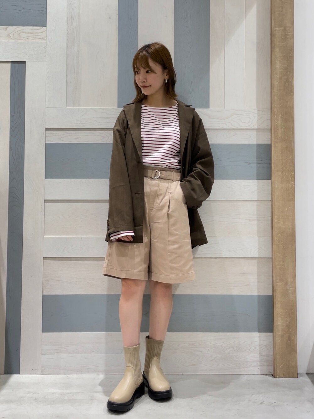 レッド系のTシャツ/カットソー、ブラウン系のノーカラージャケット、ベージュ系のその他パンツを着用したレディースの秋コーディネートの3枚目の写真