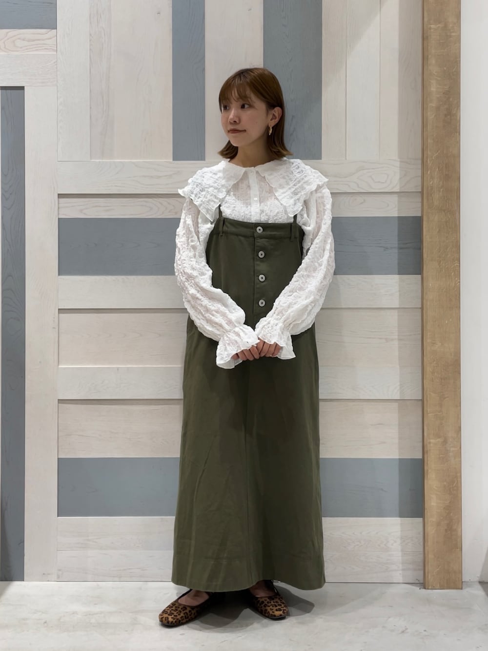 ホワイト系のシャツ/ブラウス、グリーン系のワンピース、ブラウン系のドレスシューズを着用したレディースの秋コーディネートの3枚目の写真