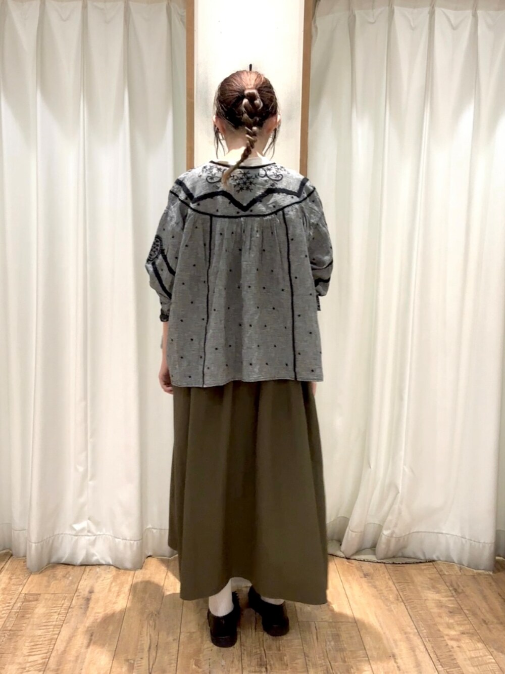 グリーン系のワンピースを着用したレディースの秋コーディネートの2枚目の写真