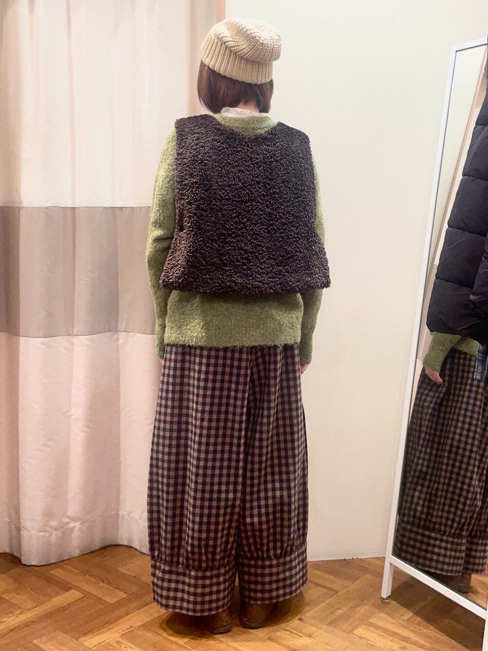 ベージュ系のドレスシューズ、グリーン系のニット/セーター、ブラウン系のベストを着用したレディースの秋コーディネートの3枚目の写真