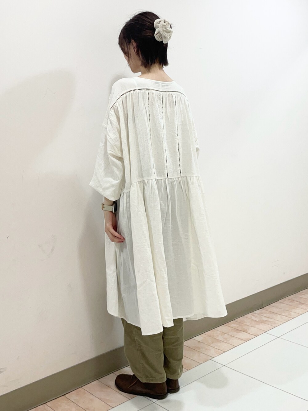 ベージュ系のドレスシューズ、ホワイト系のチュニック、グリーン系のその他パンツを着用したレディースの秋コーディネートの2枚目の写真