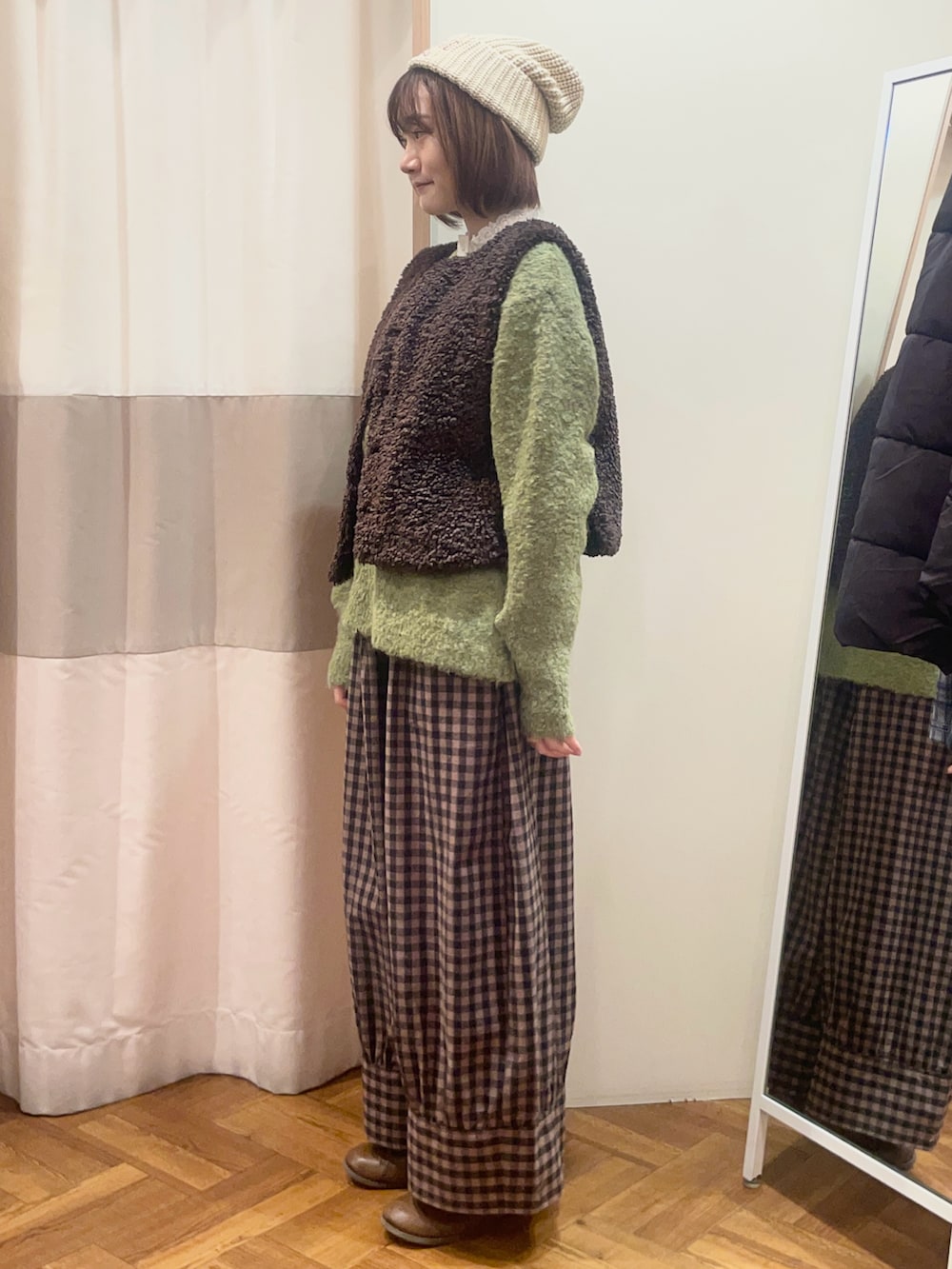 ベージュ系のドレスシューズ、グリーン系のニット/セーター、ブラウン系のベストを着用したレディースの秋コーディネートの2枚目の写真