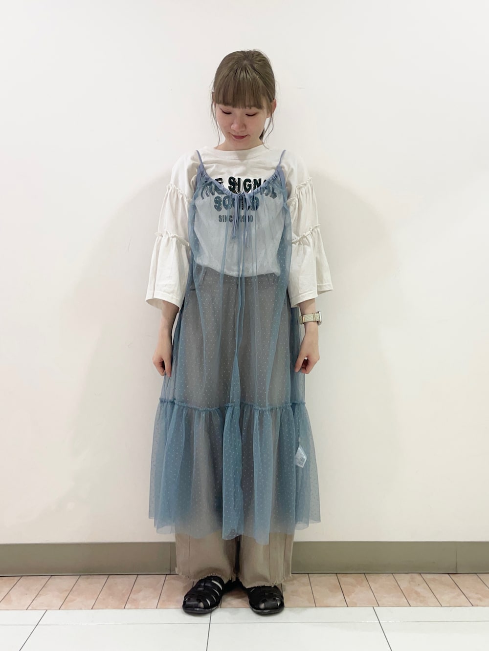 ブラウン系のサンダル、グレー系のワンピース、ホワイト系のTシャツ/カットソーを着用したレディースの秋コーディネートの2枚目の写真