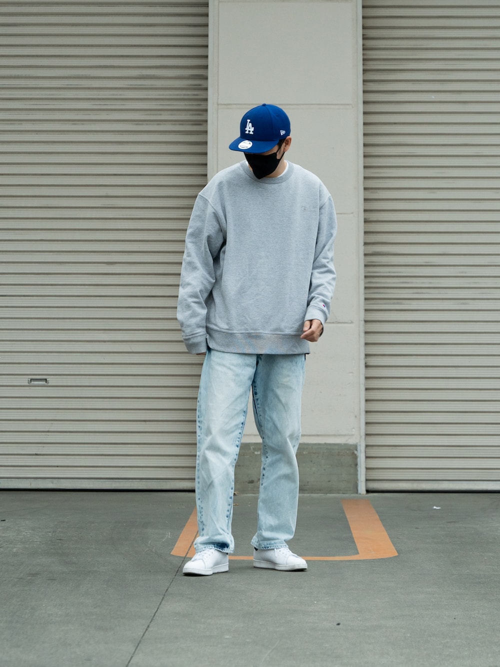 グレー系のスウェット、ブルー系のデニムパンツ、ホワイト系のスニーカーを着用したメンズの冬コーディネートの2枚目の写真