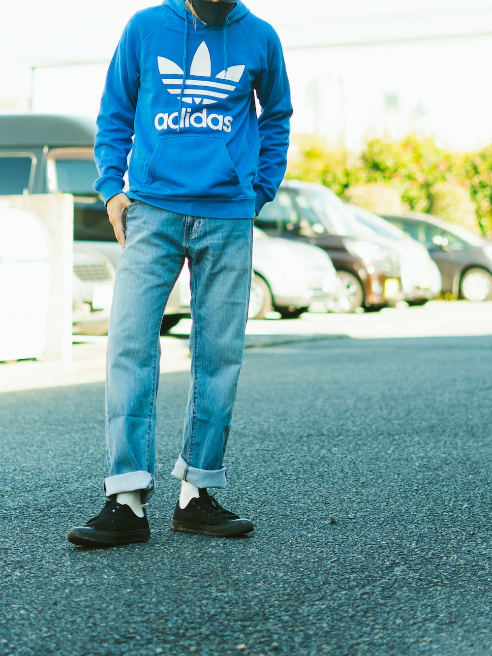 ブルー系のパーカー、ブルー系のデニムパンツ、ブラック系のスニーカーを着用したメンズの秋コーディネートの2枚目の写真