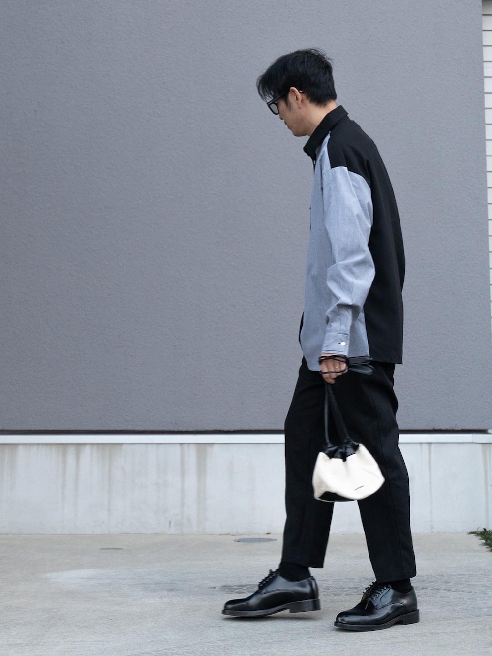 ブラック系のシャツ/ブラウス、ホワイト系のショルダーバッグ、ブラック系のスラックスを着用したメンズの冬コーディネートの2枚目の写真