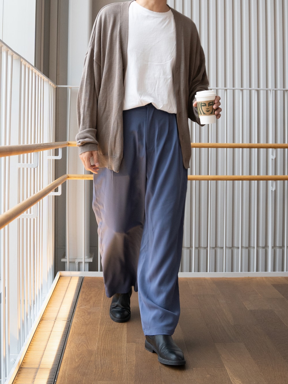 ブラウン系のカーディガン/ボレロ、ホワイト系のTシャツ/カットソー、ブルー系のスラックスを着用したメンズの春コーディネートの2枚目の写真