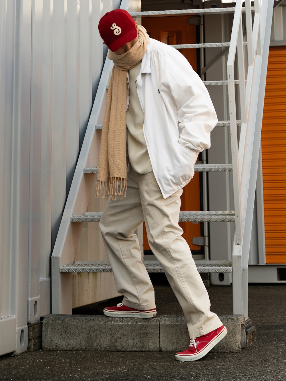 レッド系のスニーカー、ホワイト系のトップス、ホワイト系のパンツを着用したメンズの冬コーディネートの2枚目の写真