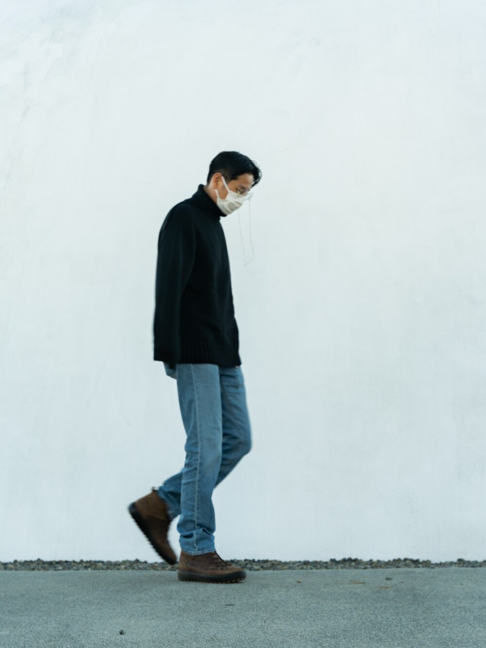 ブラック系のニット/セーター、ブルー系のデニムパンツ、ブラウン系のブーツを着用したメンズの冬コーディネートの2枚目の写真