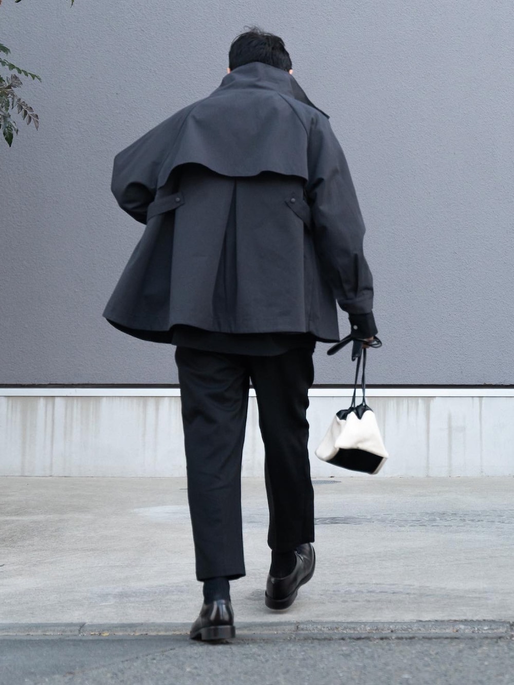 グレー系のジャケット/アウター、ブラック系のシャツ/ブラウス、ブラック系のスラックスを着用したメンズの冬コーディネートの2枚目の写真