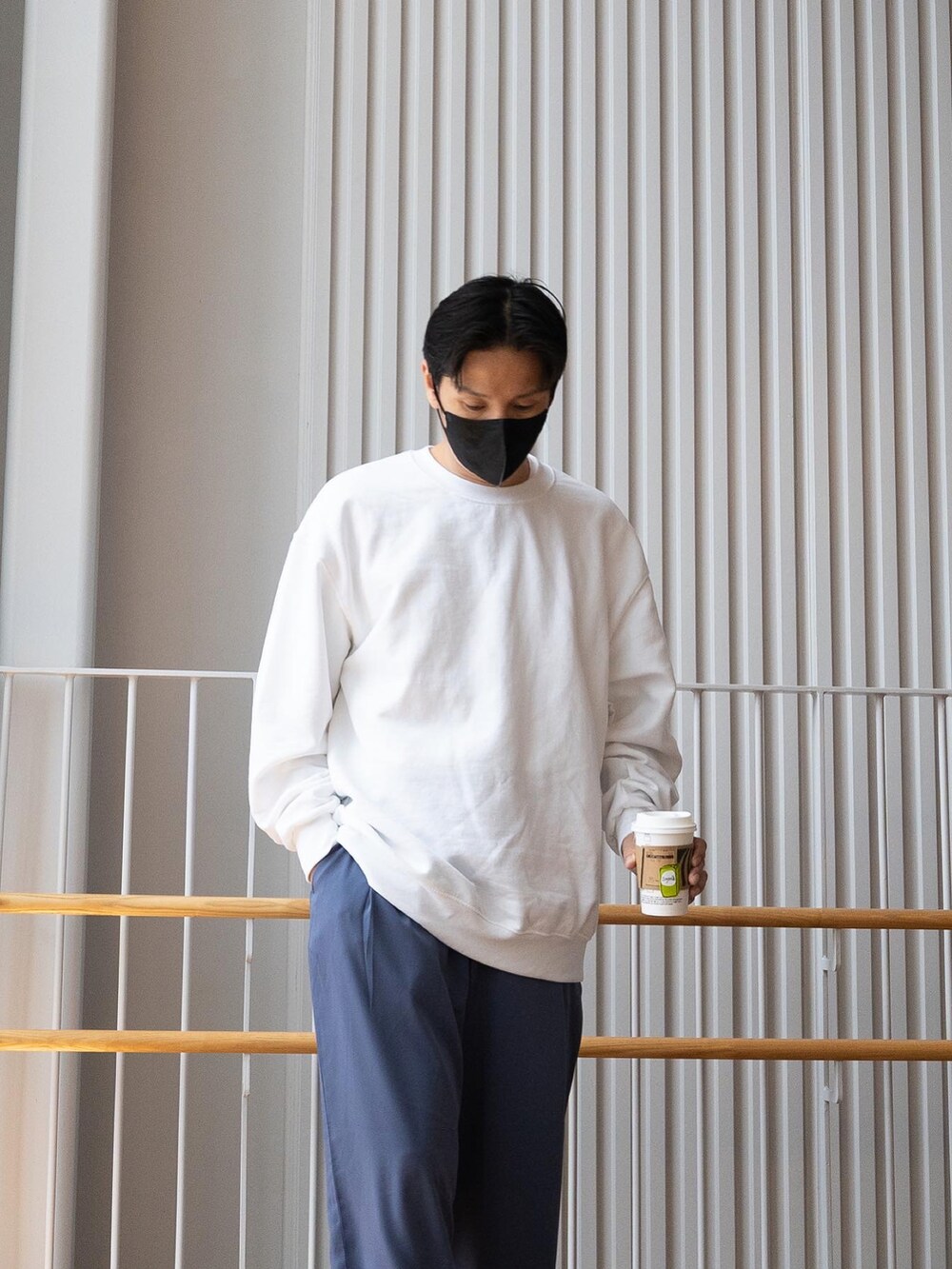 ホワイト系のスウェット、ブルー系のスラックス、ブラック系のブーツを着用したメンズの春コーディネートの4枚目の写真