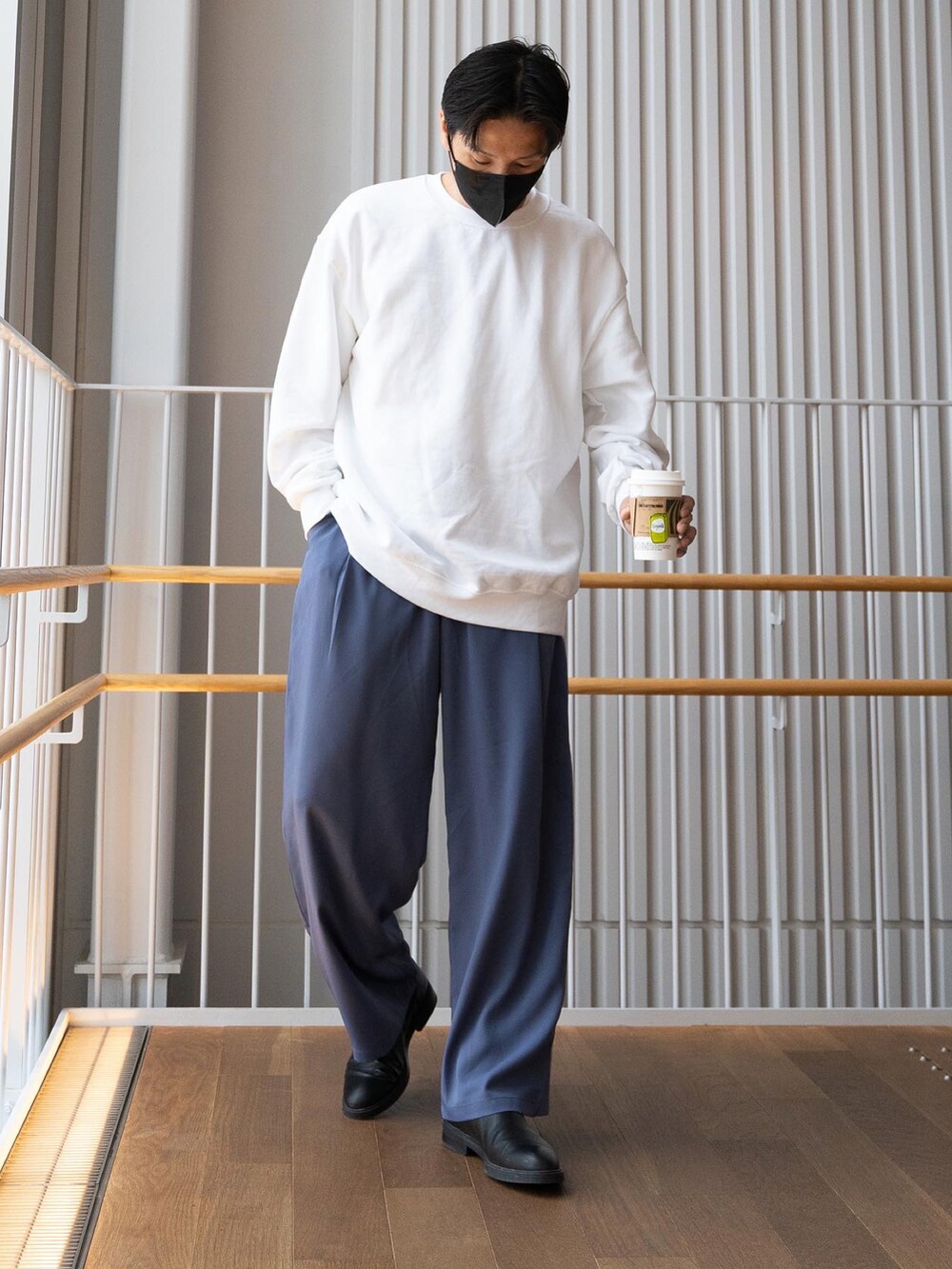 ホワイト系のスウェット、ブルー系のスラックス、ブラック系のブーツを着用したメンズの春コーディネートの5枚目の写真