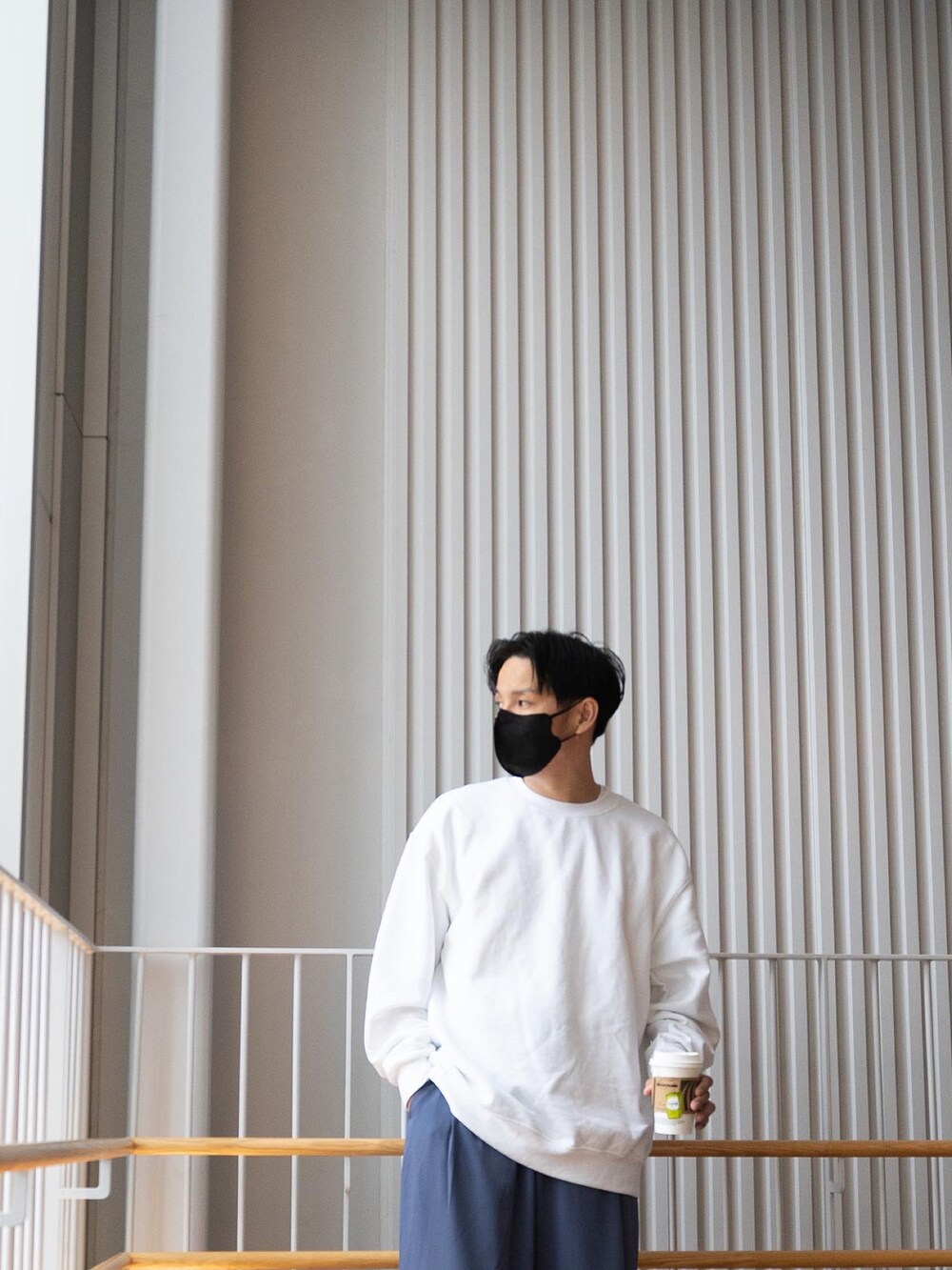 ホワイト系のスウェット、ブルー系のスラックス、ブラック系のブーツを着用したメンズの春コーディネートの2枚目の写真