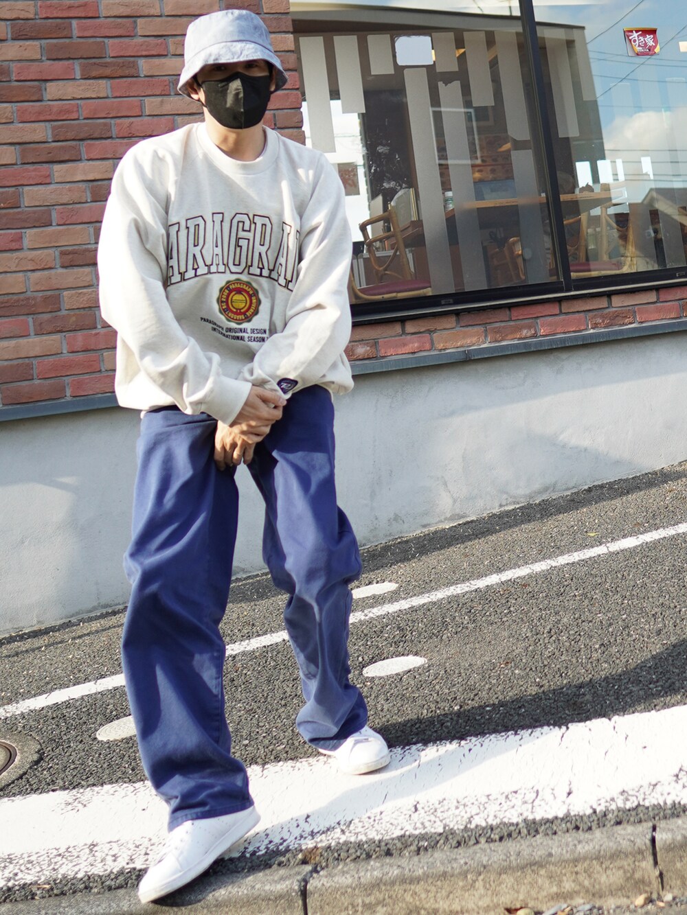 ブルー系のデニムパンツ、ホワイト系のスニーカー、ホワイト系のスウェットを着用したメンズの春コーディネートの4枚目の写真