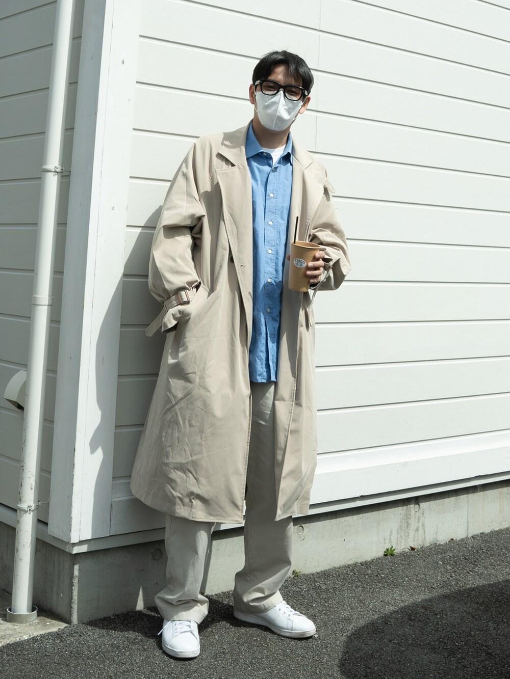 ブルー系のシャツ/ブラウス、ベージュ系のトレンチコート、ホワイト系のパンツを着用したメンズの春コーディネートの2枚目の写真