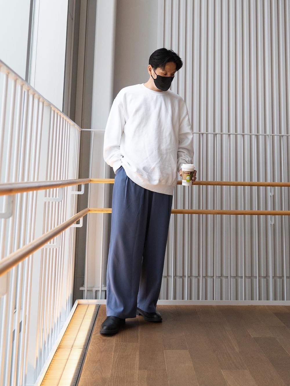 ホワイト系のスウェット、ブルー系のスラックス、ブラック系のブーツを着用したメンズの春コーディネートの3枚目の写真