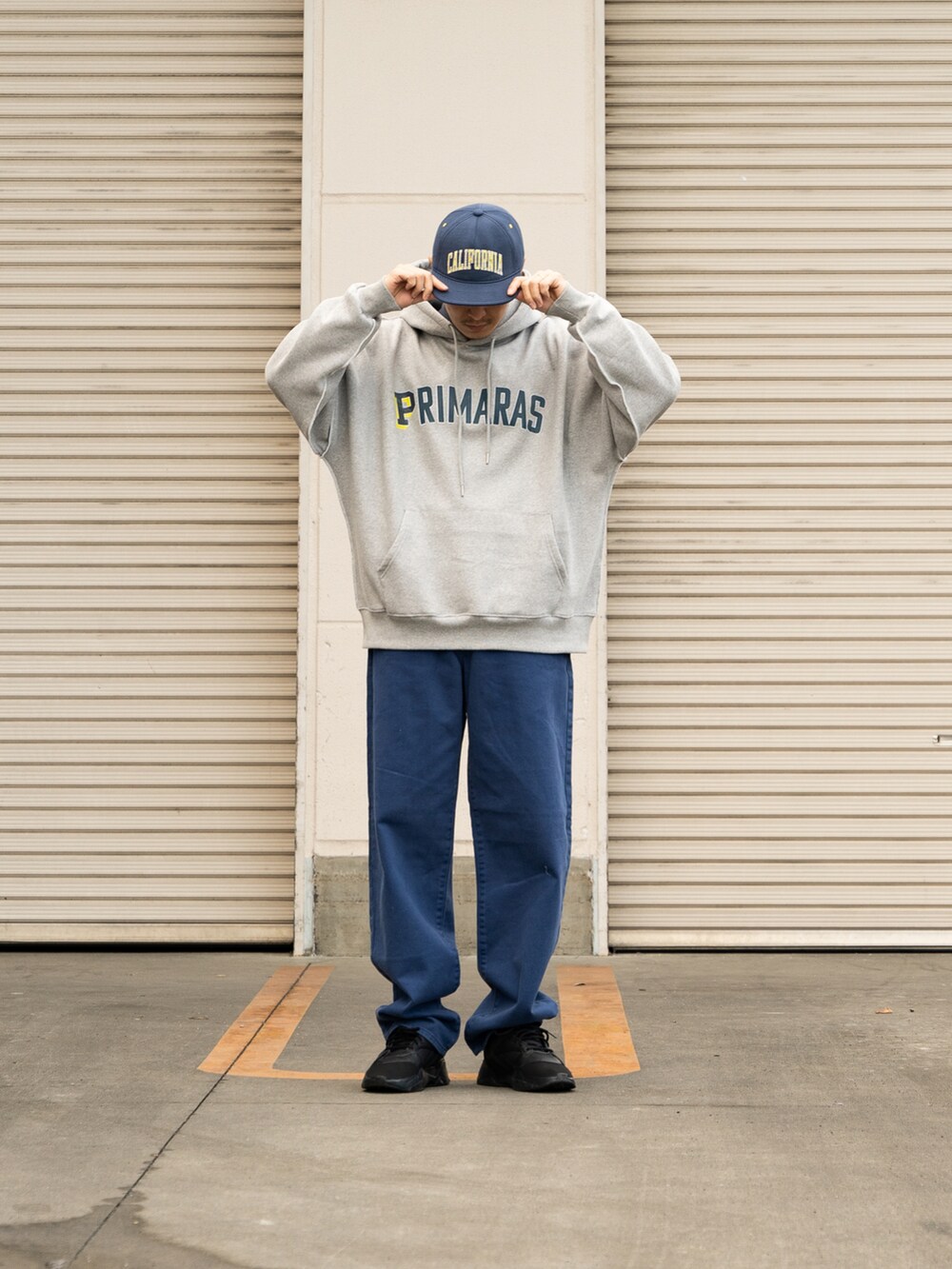 ブラック系のスニーカー、ブルー系のデニムパンツ、グレー系のパーカーを着用したメンズの冬コーディネートの2枚目の写真