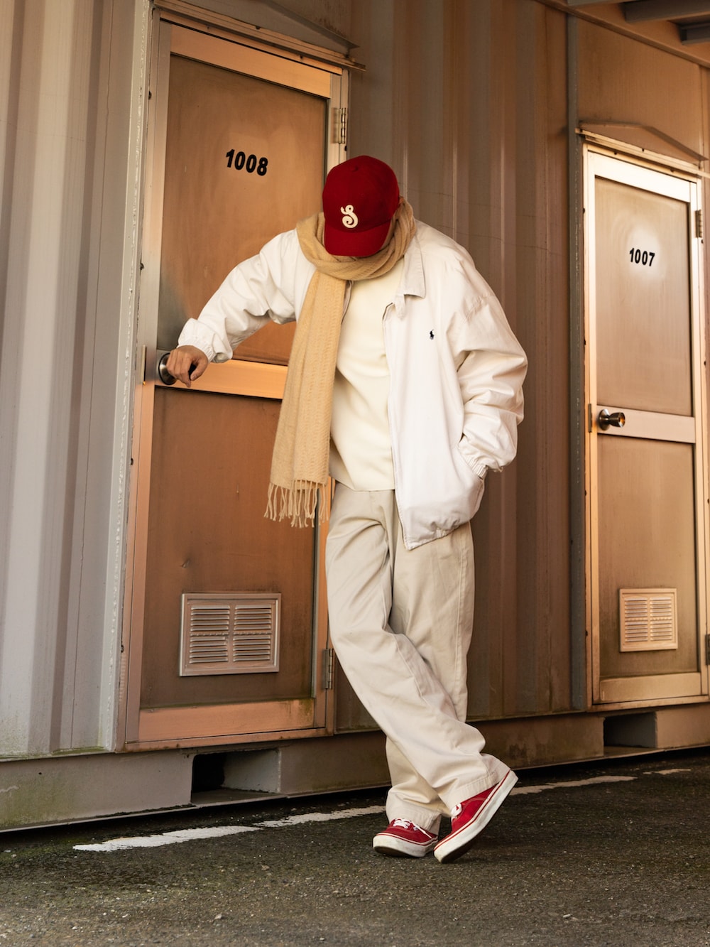 レッド系のスニーカー、ホワイト系のトップス、ホワイト系のパンツを着用したメンズの冬コーディネートの3枚目の写真