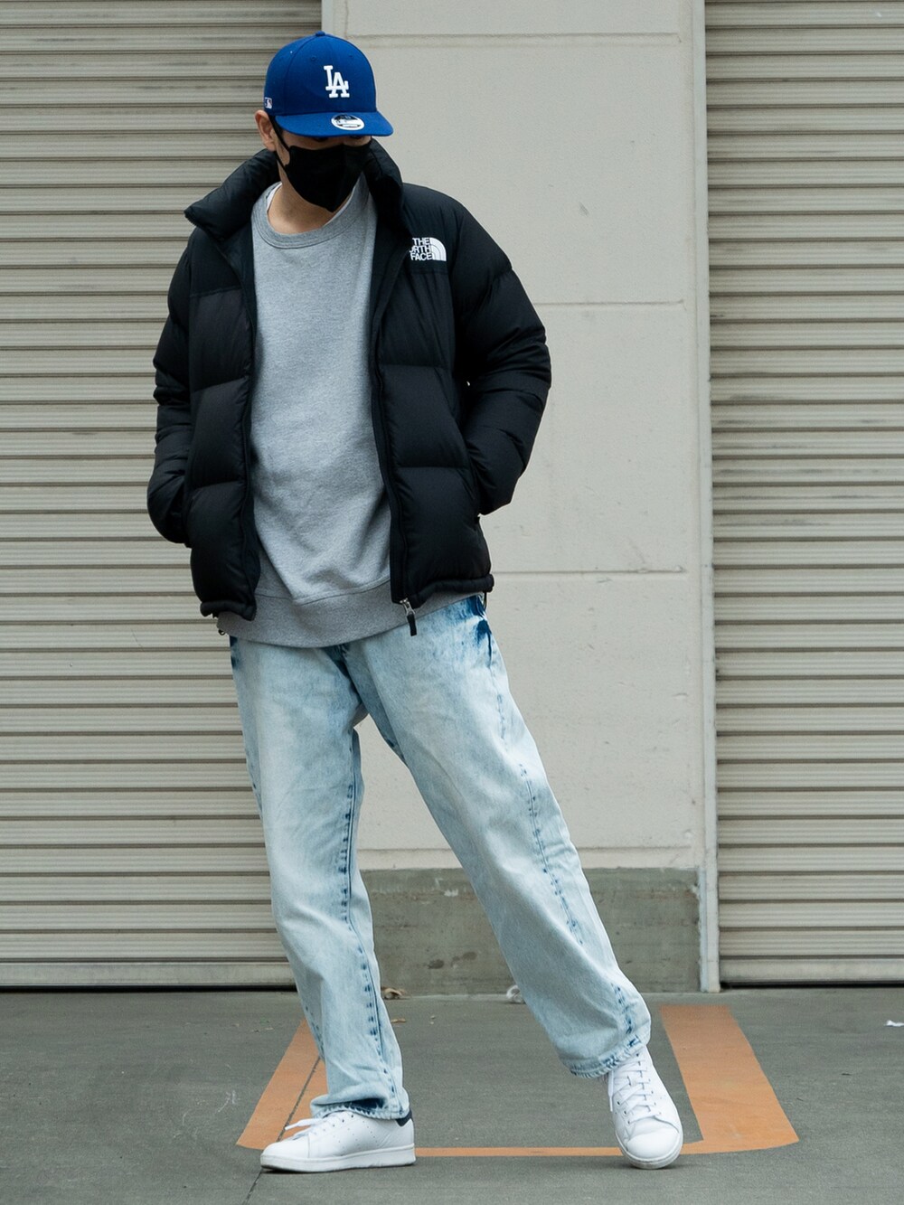 ブラック系のダウンジャケット/コート、グレー系のスウェット、ホワイト系のスニーカーを着用したメンズの冬コーディネートの2枚目の写真