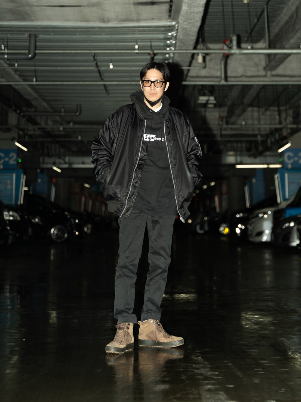 ブラック系のパーカー、ブラウン系のブーツ、ブラック系のチノパンツを着用したメンズの冬コーディネートの2枚目の写真