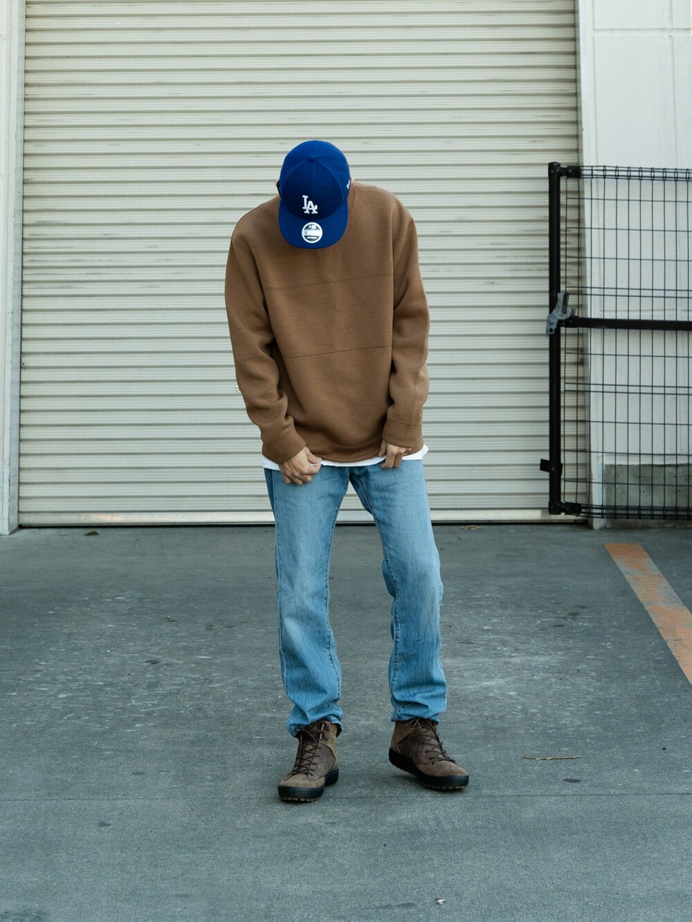 ベージュ系のスウェット、ブルー系のデニムパンツ、ブラウン系のブーツを着用したメンズの冬コーディネートの2枚目の写真