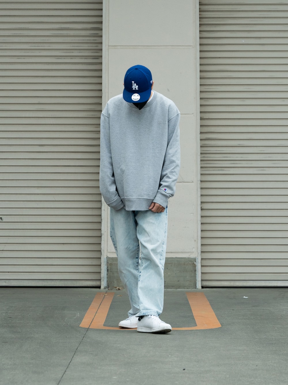 グレー系のスウェット、ブルー系のデニムパンツ、ホワイト系のスニーカーを着用したメンズの冬コーディネートの3枚目の写真