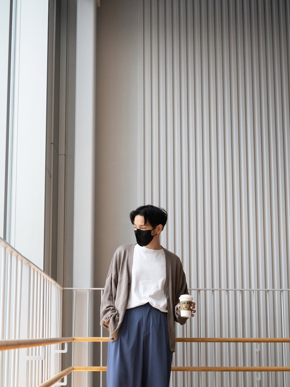 ブラウン系のカーディガン/ボレロ、ホワイト系のTシャツ/カットソー、ブルー系のスラックスを着用したメンズの春コーディネートの3枚目の写真