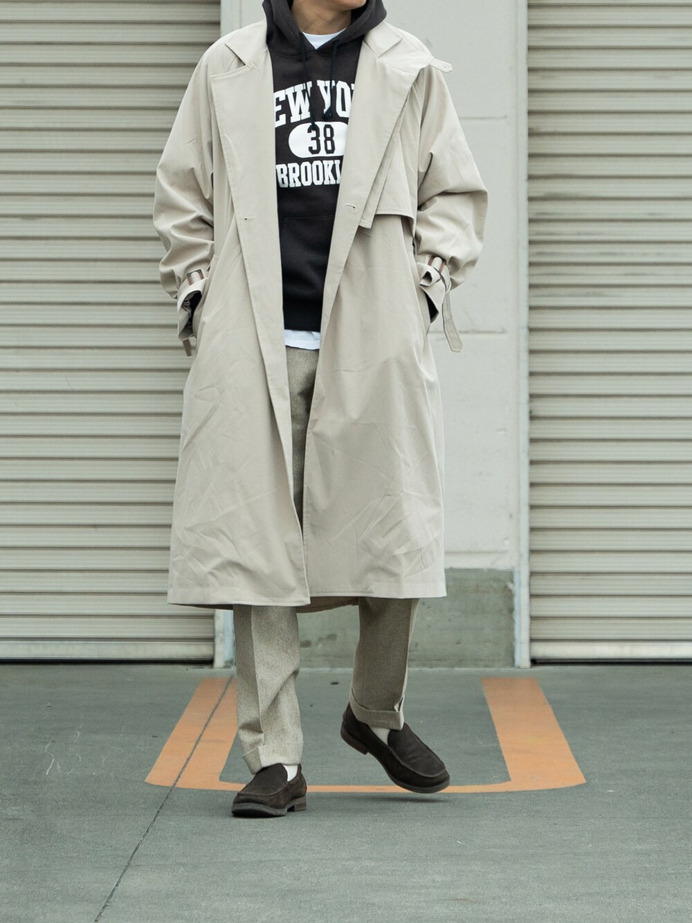 ベージュ系のトレンチコート、ベージュ系のパンツ、ブラウン系のシューズを着用したメンズの冬コーディネートの2枚目の写真