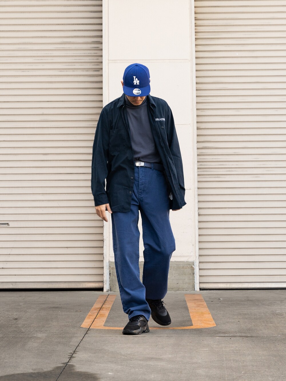 ブラック系のスニーカー、ブルー系のデニムパンツ、ブルー系のトップスを着用したメンズの冬コーディネートの2枚目の写真