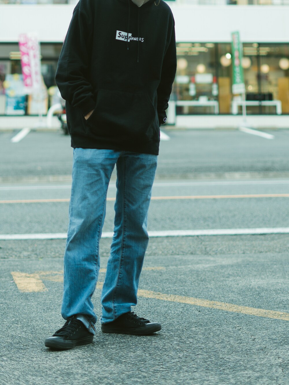 ブルー系のデニムパンツ、ブラック系のスニーカーを着用したメンズの秋コーディネートの2枚目の写真