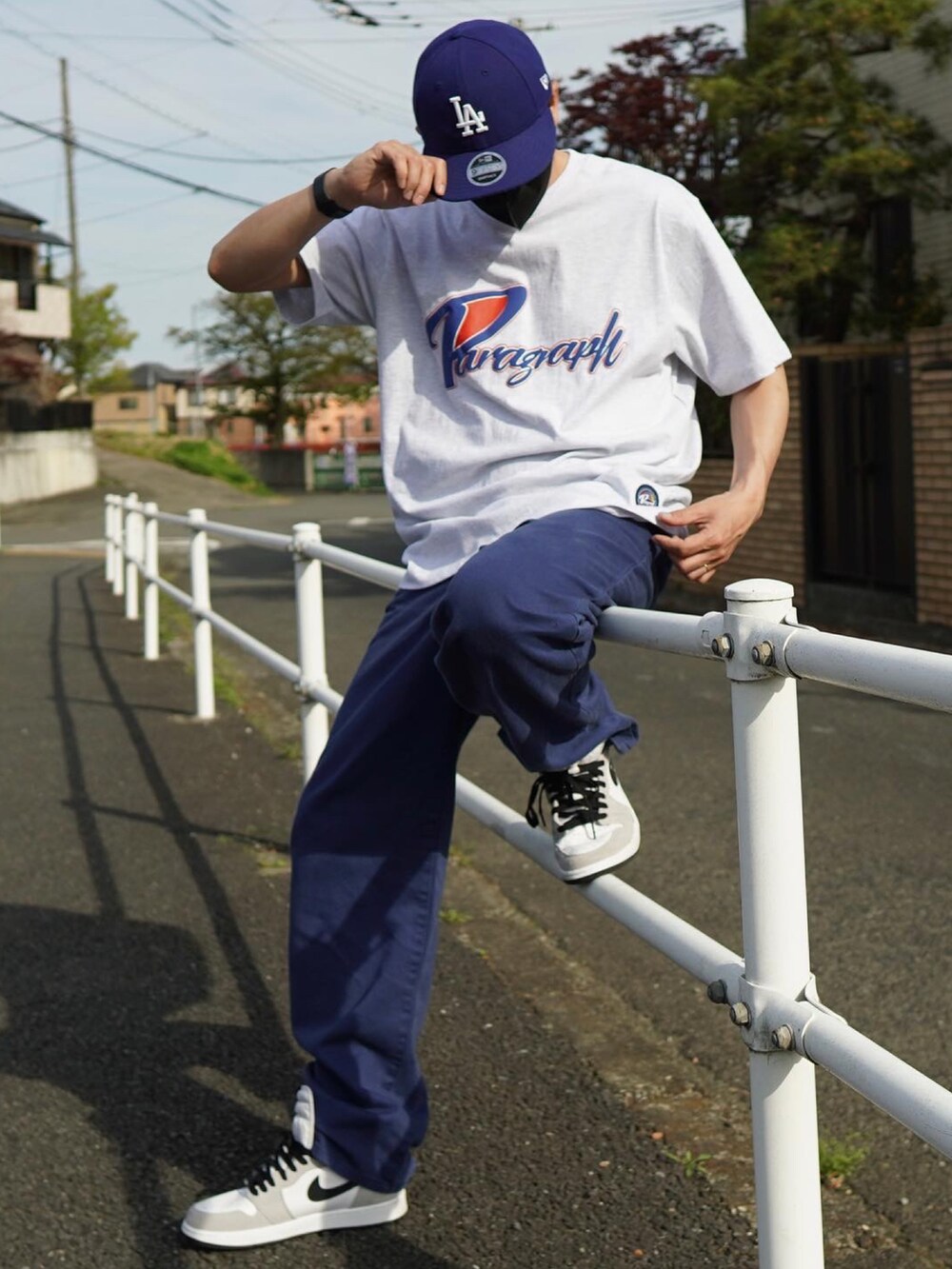 ホワイト系のTシャツ/カットソー、ブルー系のデニムパンツ、ホワイト系のスニーカーを着用したメンズの春コーディネートの2枚目の写真