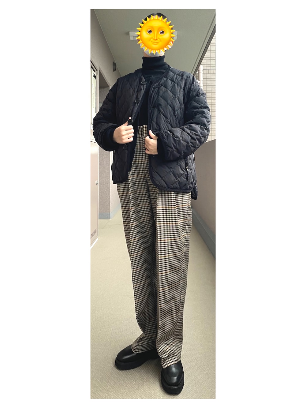 ベージュ系のスラックス、ブラック系のブーツ、ブラック系のダウンジャケット/コートを着用したレディースの冬コーディネートの2枚目の写真