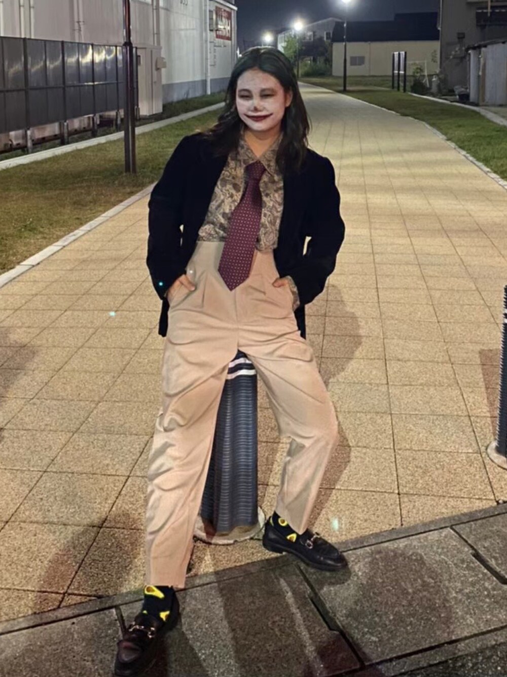 ベージュ系のスラックス、ブラック系のローファー、ブラック系のテーラードジャケットを着用したレディースの夏コーディネートの2枚目の写真