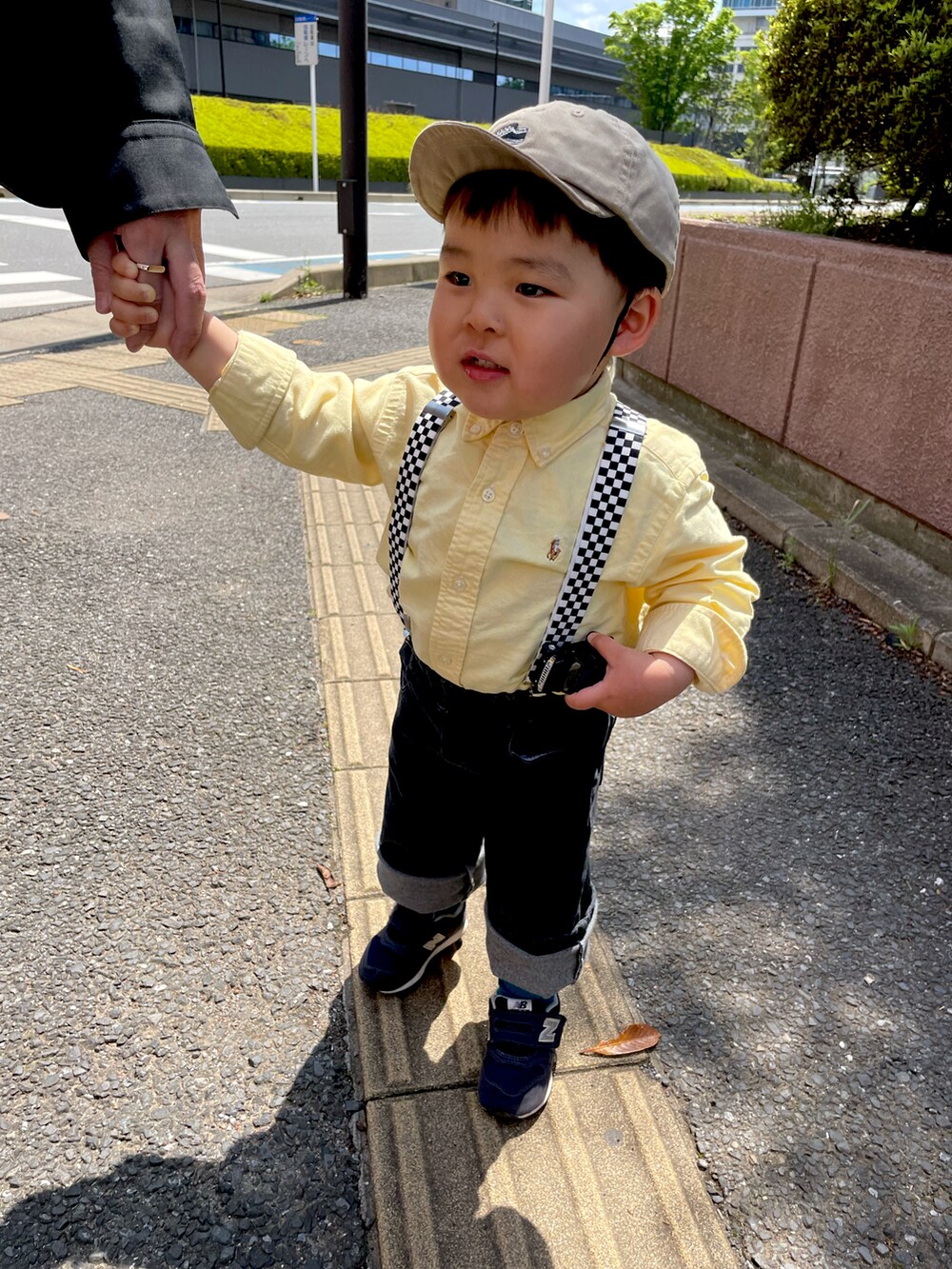 ブラック系のデニムパンツ、ブラック系のスニーカー、イエロー系のシャツ/ブラウスを着用したキッズの春コーディネートの2枚目の写真