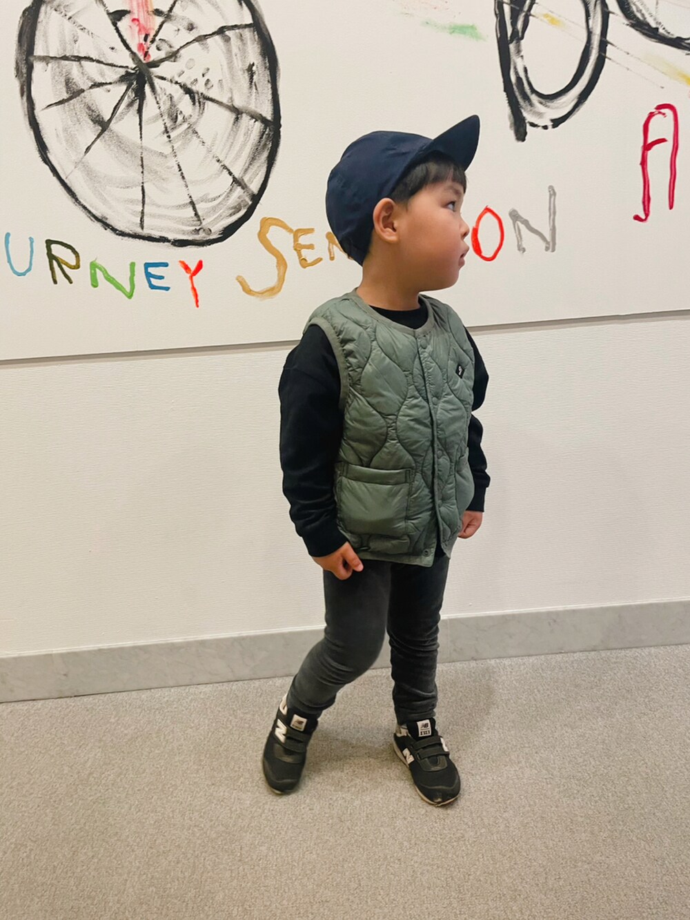 グレー系のその他パンツ、グリーン系のベスト、ブラック系のTシャツ/カットソーを着用したキッズの秋コーディネートの2枚目の写真