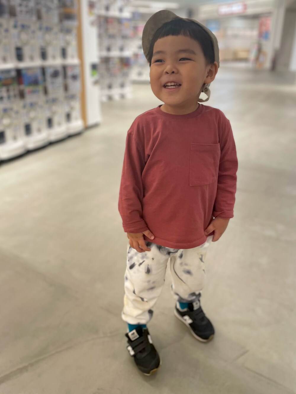 レッド系のTシャツ/カットソー、ホワイト系のスウェットパンツ、ブラック系のスニーカーを着用したキッズの秋コーディネートの2枚目の写真