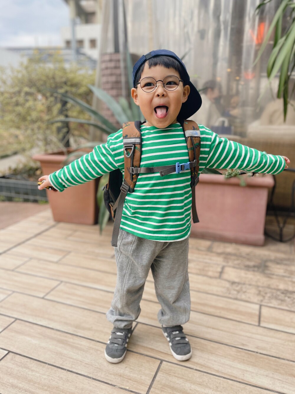 グレー系のスウェットパンツ、グリーン系のTシャツ/カットソー、ブラウン系のバックパック/リュックを着用したキッズの冬コーディネートの2枚目の写真