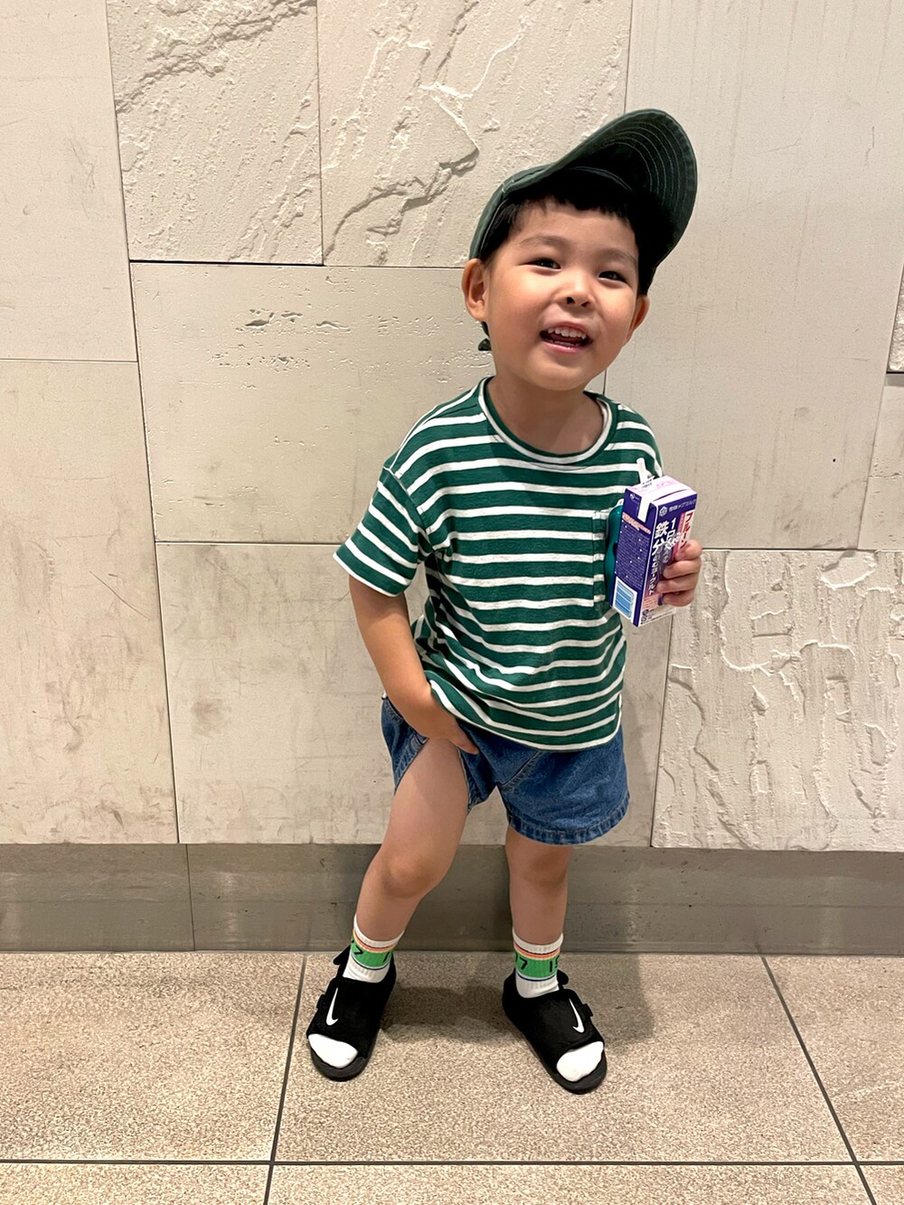 グリーン系のTシャツ/カットソー、ブルー系のデニムパンツ、ブラック系のサンダルを着用したキッズの秋コーディネートの2枚目の写真
