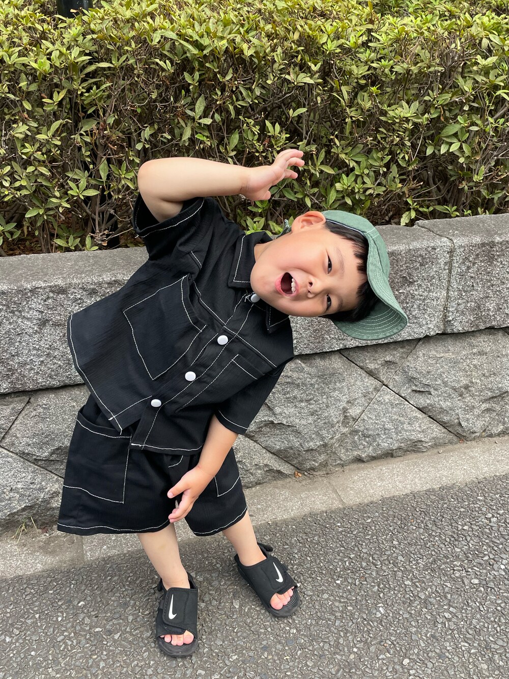 ブラック系のシャツ/ブラウス、ブラック系のサンダル、グリーン系のキャップを着用したキッズの秋コーディネートの2枚目の写真