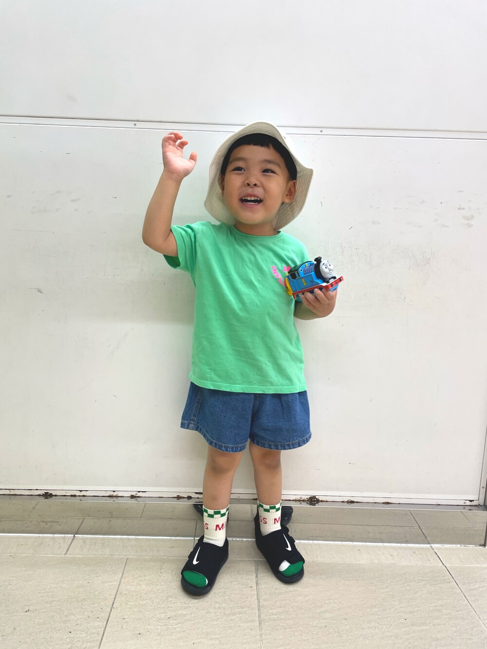 グリーン系のTシャツ/カットソー、ブルー系のデニムパンツ、ブラック系のスニーカーを着用したキッズの秋コーディネートの2枚目の写真