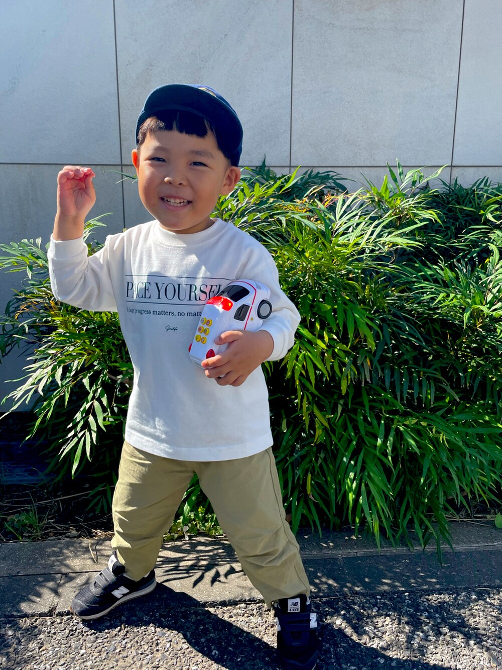 ベージュ系のカーゴパンツ、ホワイト系のTシャツ/カットソー、ブラック系のスニーカーを着用したキッズの秋コーディネートの2枚目の写真