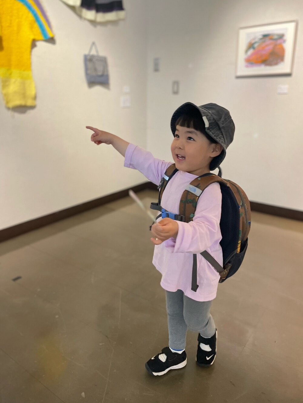 グレー系のパンツ、ピンク系のTシャツ/カットソー、ブラウン系のバックパック/リュックを着用したキッズの春コーディネートの2枚目の写真