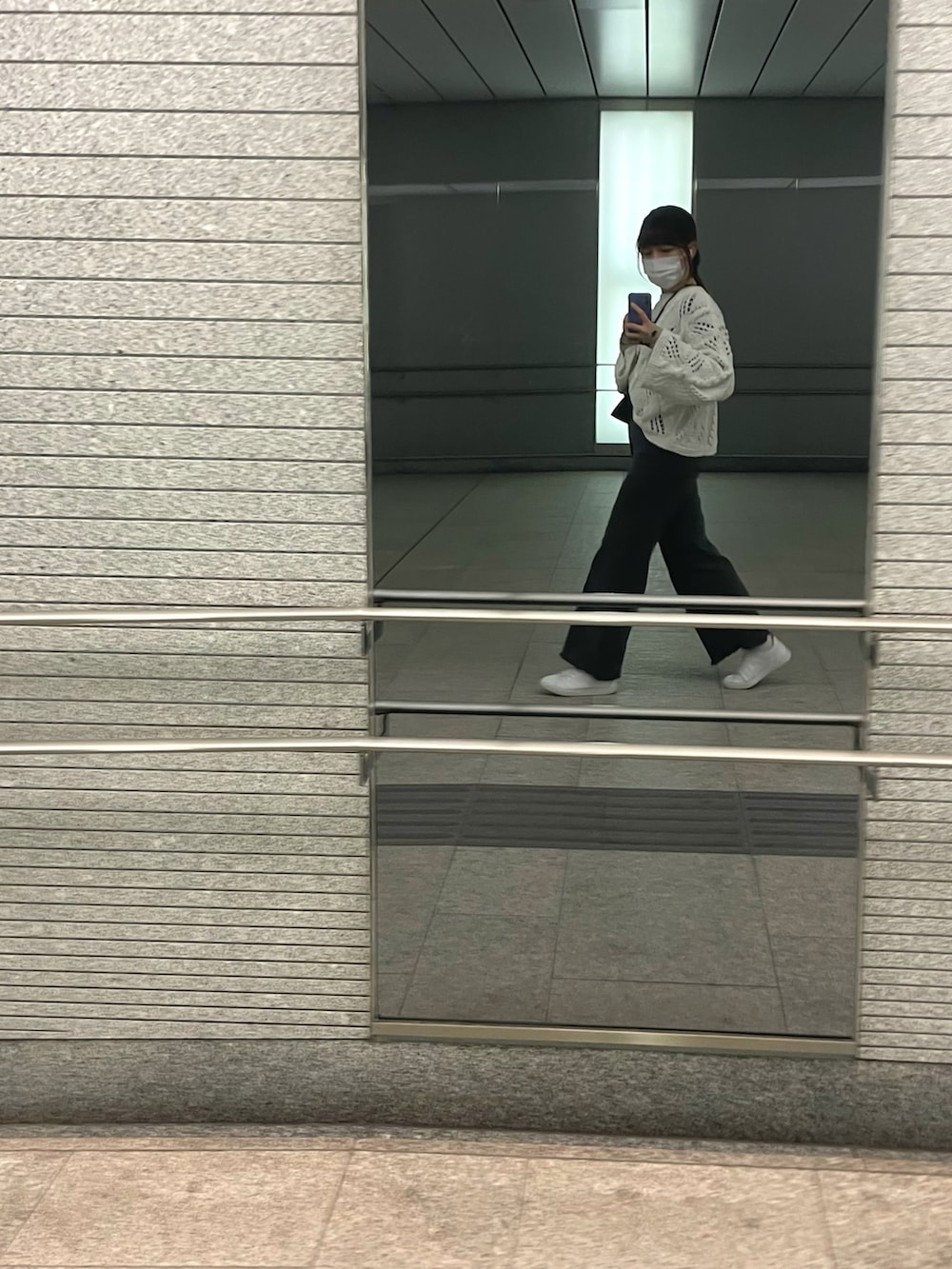 ブラック系のデニムパンツ、ホワイト系のスニーカー、ブラック系のショルダーバッグを着用したレディースの夏コーディネートの2枚目の写真