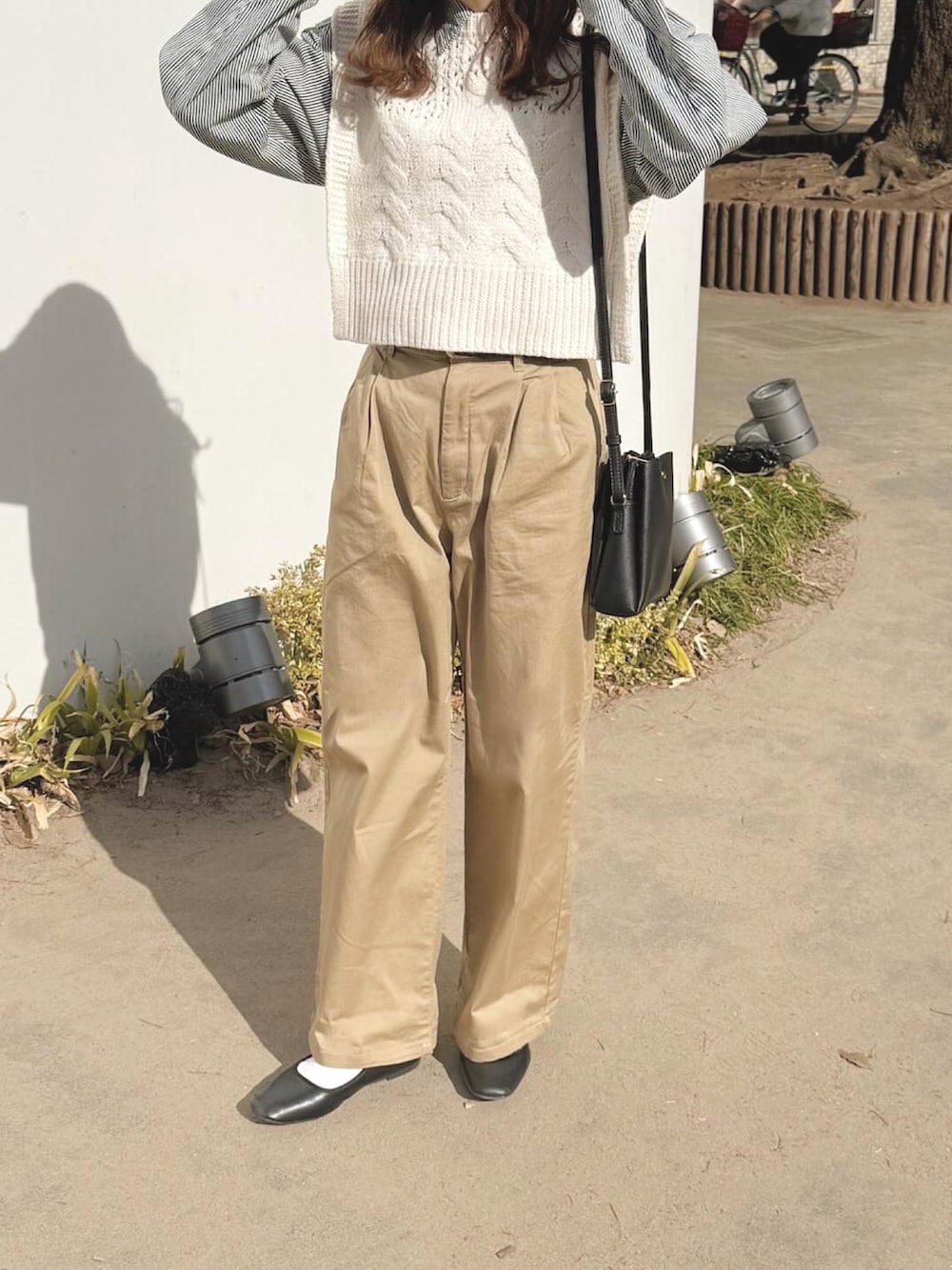 ホワイト系のベスト、ブルー系のシャツ/ブラウス、イエロー系のチノパンツを着用したレディースの春コーディネートの2枚目の写真