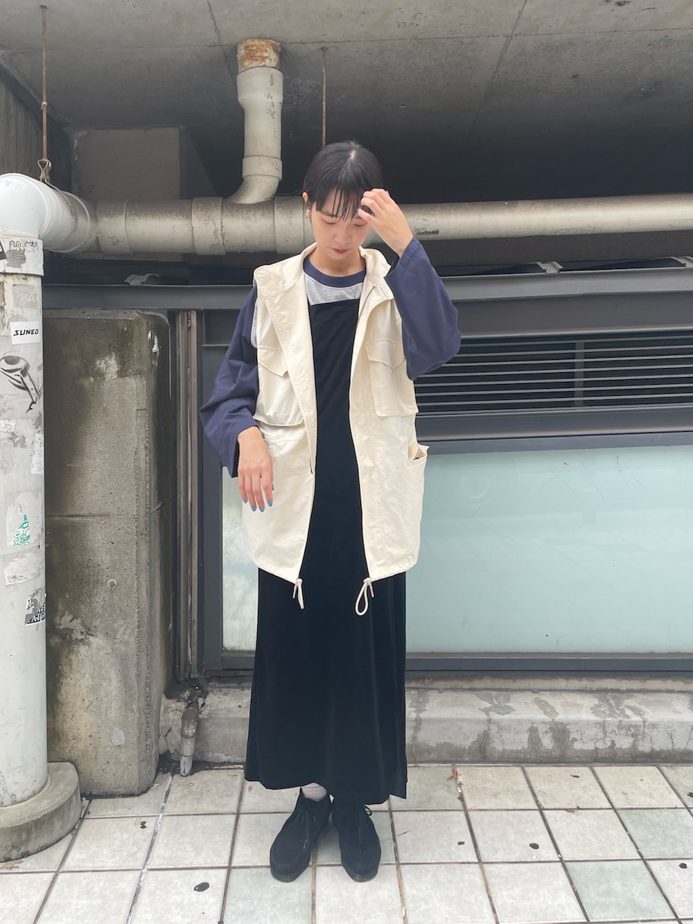 グレー系のTシャツ/カットソー、ブラック系のワンピース、ホワイト系のベストを着用したレディースの秋コーディネートの2枚目の写真