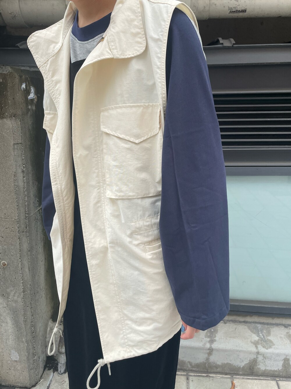 グレー系のTシャツ/カットソー、ブラック系のワンピース、ホワイト系のベストを着用したレディースの秋コーディネートの4枚目の写真