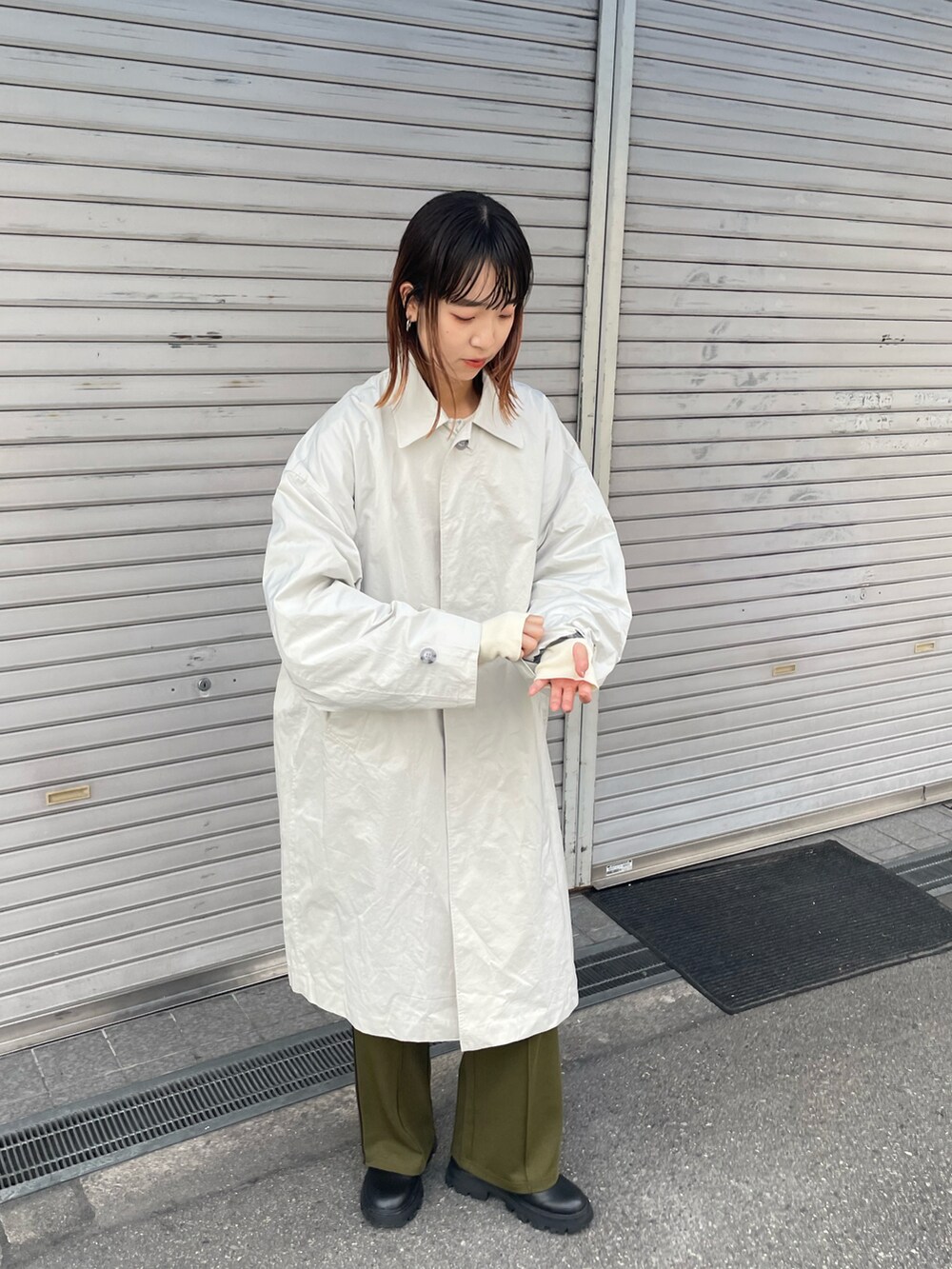 ベージュ系のステンカラーコート、グリーン系のその他パンツを着用したレディースの秋コーディネートの3枚目の写真