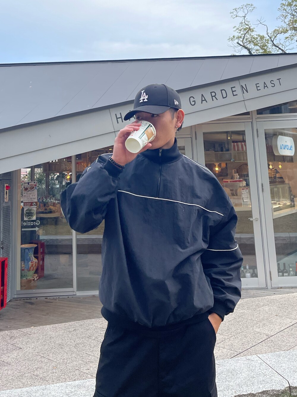 ブラック系のカーゴパンツ、ホワイト系のスニーカー、ブラック系のその他アウターを着用したメンズの秋コーディネートの2枚目の写真